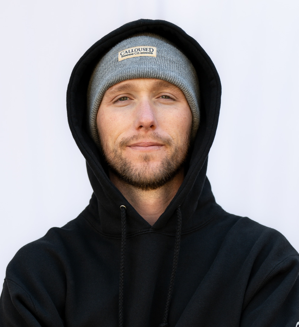 Man wearing a black hoodie and gray beanie with 'Calloused Co' logo on a white background
