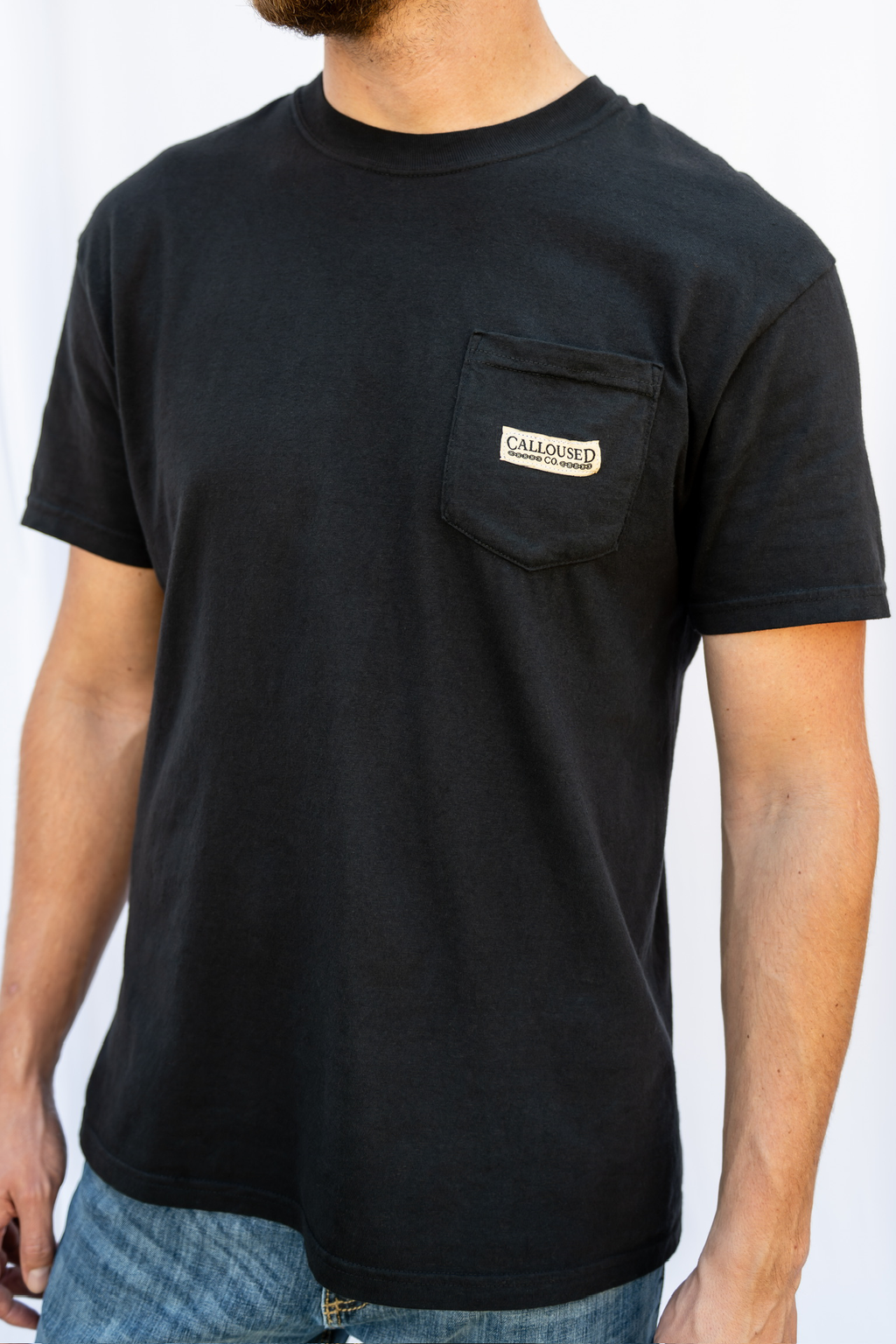 Person wearing a black t-shirt with 'Calloused Co' logo on a white background