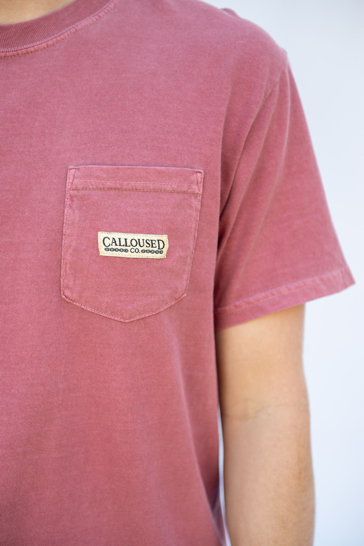 Red t-shirt with 'Calloused Co' brand label on a white background