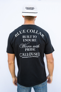 Person wearing a black t-shirt with white'Blue Collar Built to Endure Worn with Pride' text, 'Calloused Co' logo, and a white cap with 'Calloused Co' branding.