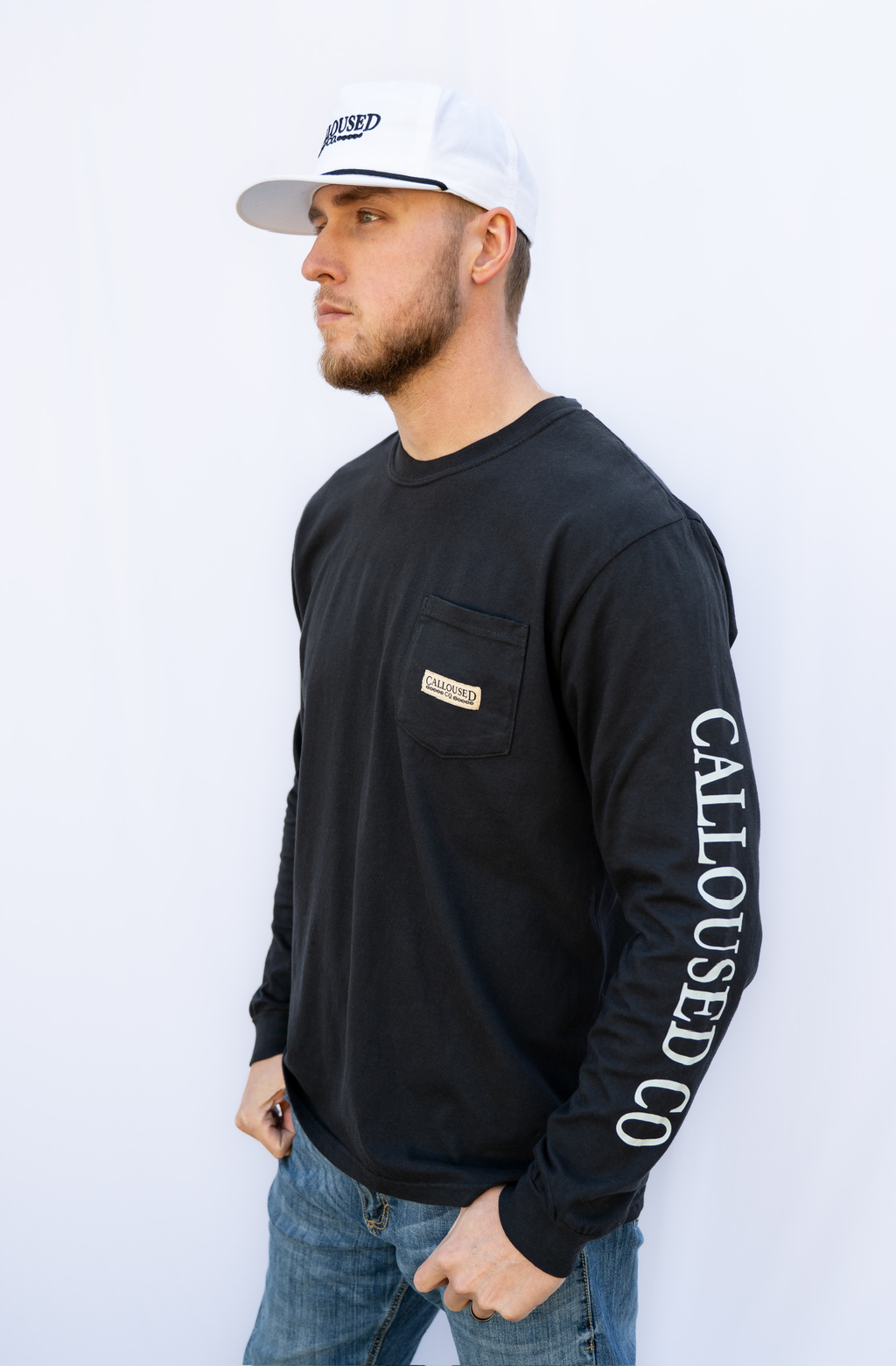 Man wearing a black long-sleeve shirt with 'Calloused Co.' branding on a white background