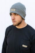 Man wearing a gray beanie and black shirt with 'Calloused Co' logo against a white background