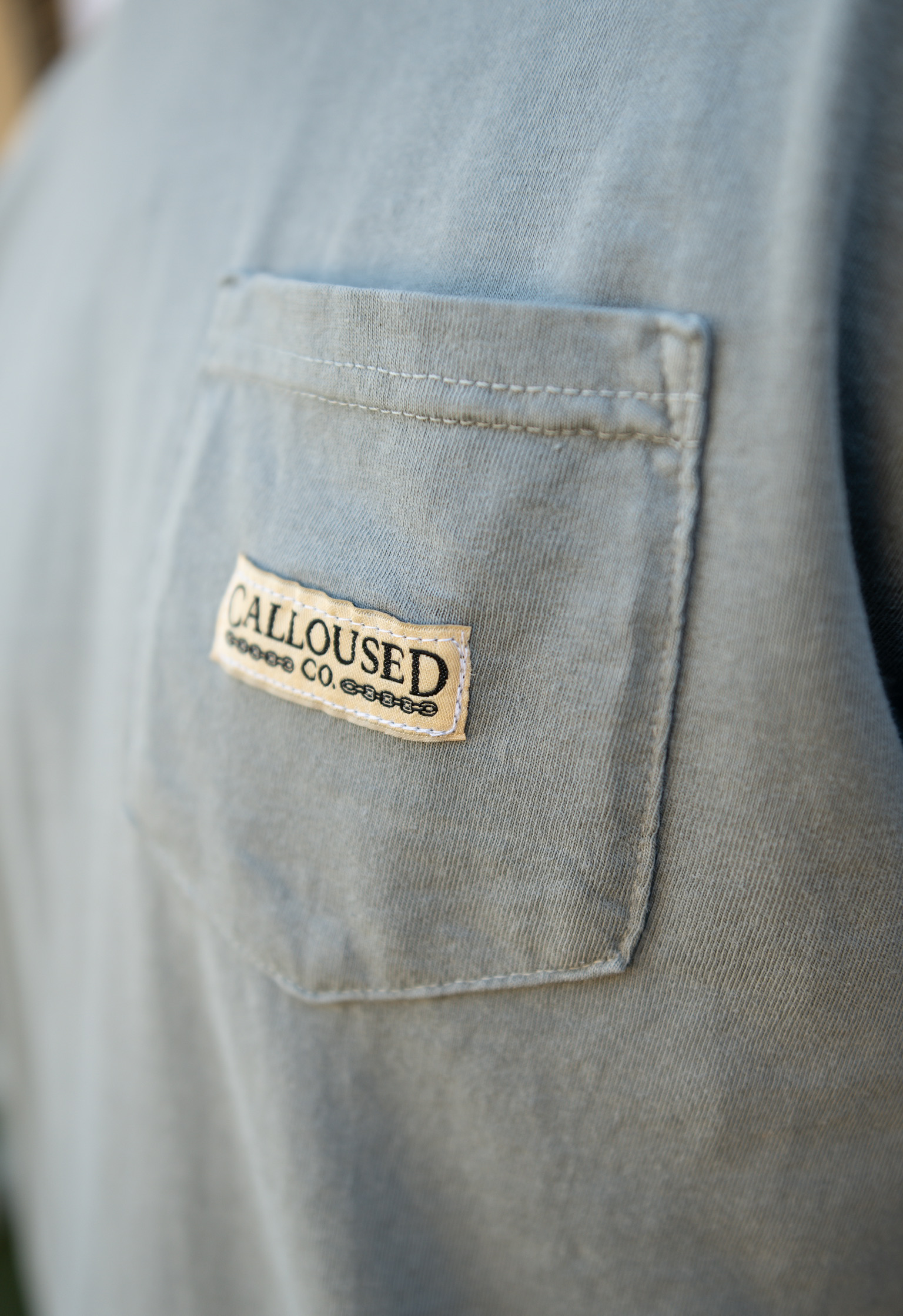 Close-up of a shirt pocket with 'Calloused Co' label